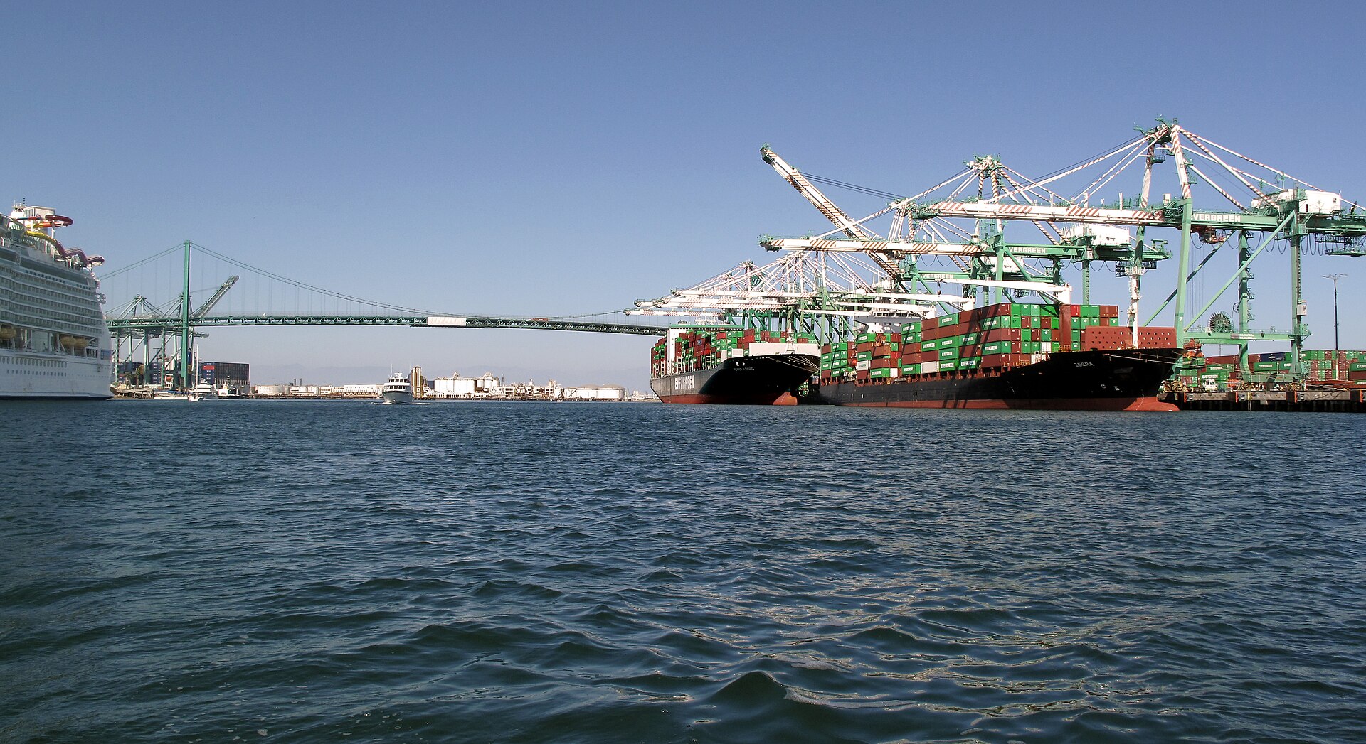 Container ships beneath port gantry cranes